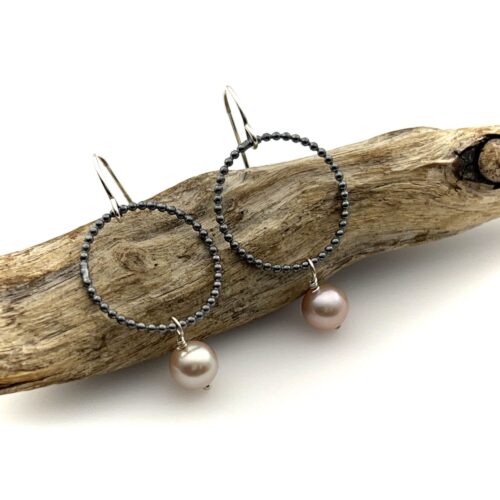 Pink pearl dangle earrings with a small circle of beaded silver wire and a pearl drop below.